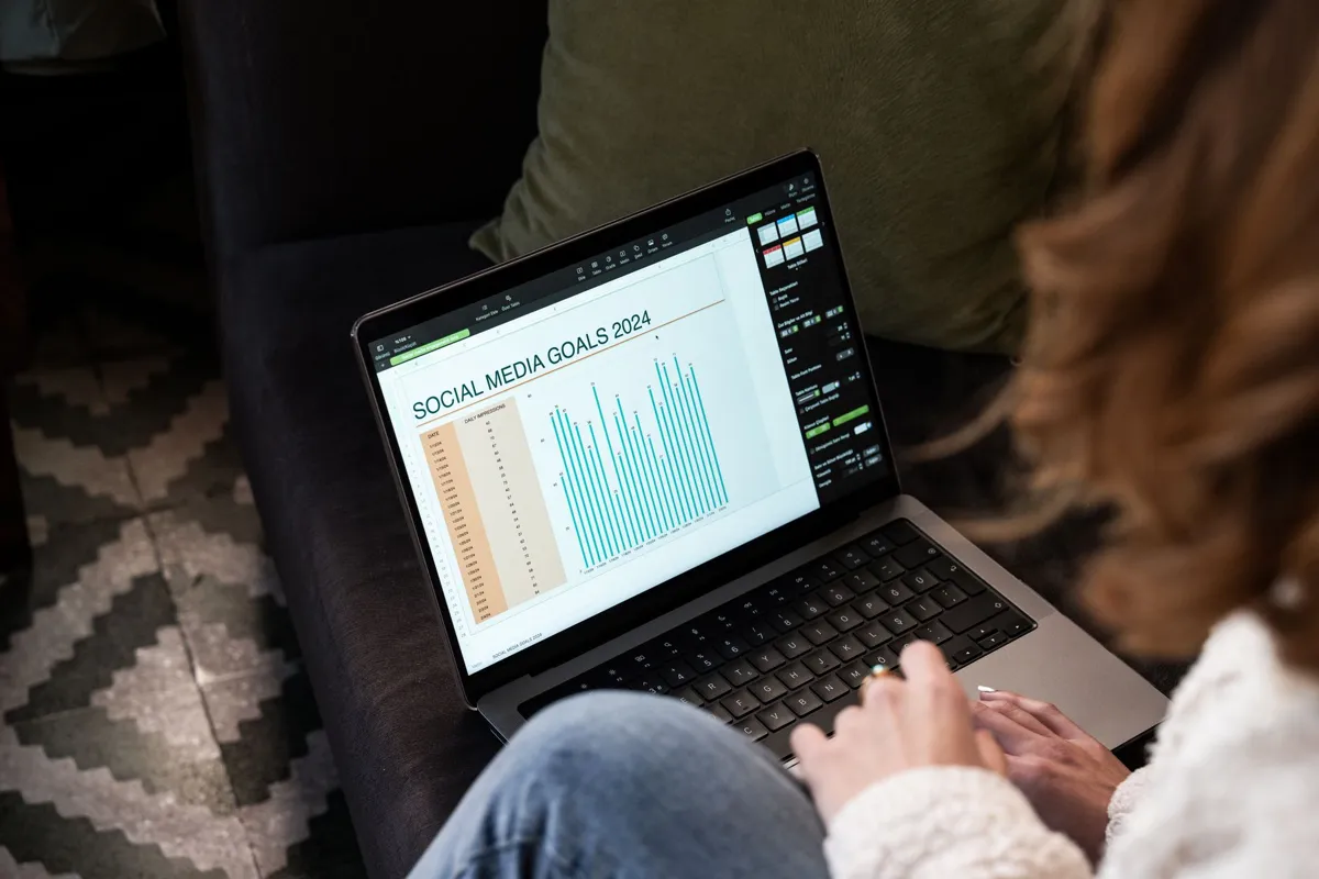 Marketer reviewing a social media goals chart on a laptop