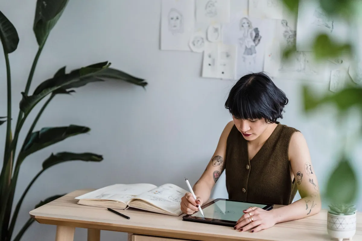 Designer drawing on a tablet at her desk