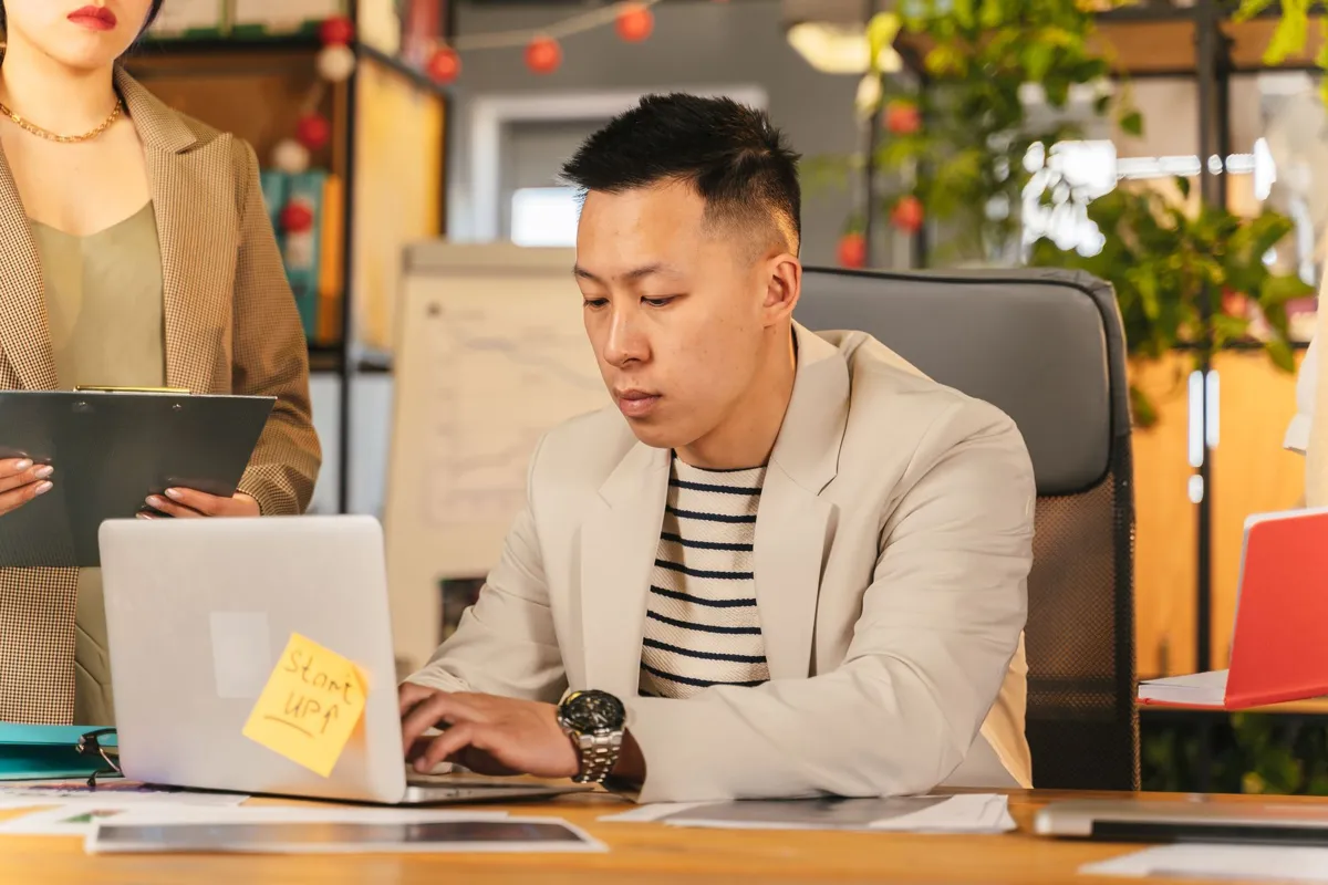Office worker typing a prompt on a laptop
