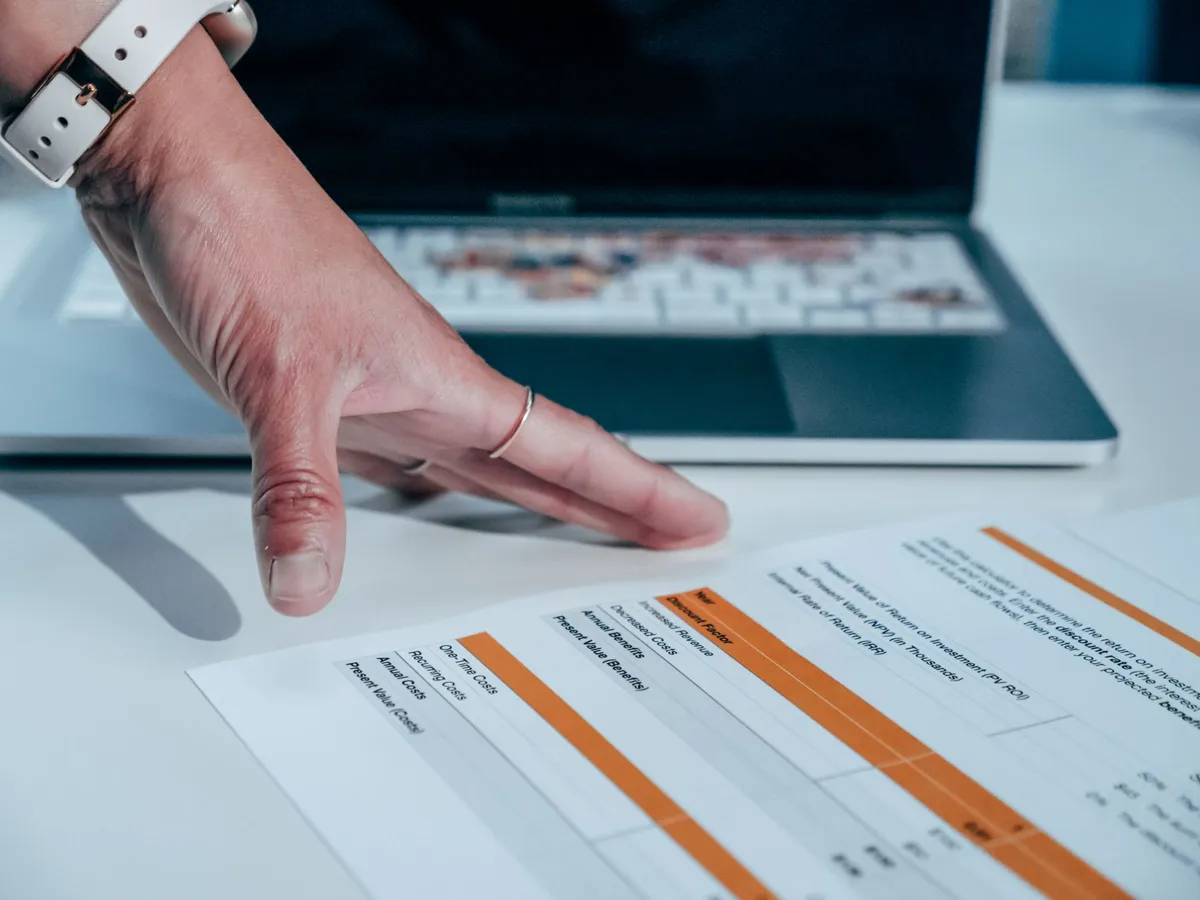 Laptop showing a spreadsheet next to a chart dashboard