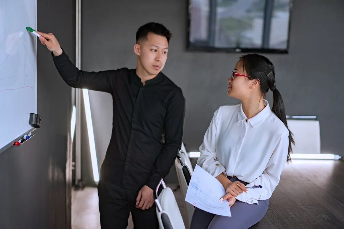 Trainer explaining at a whiteboard in a workshop