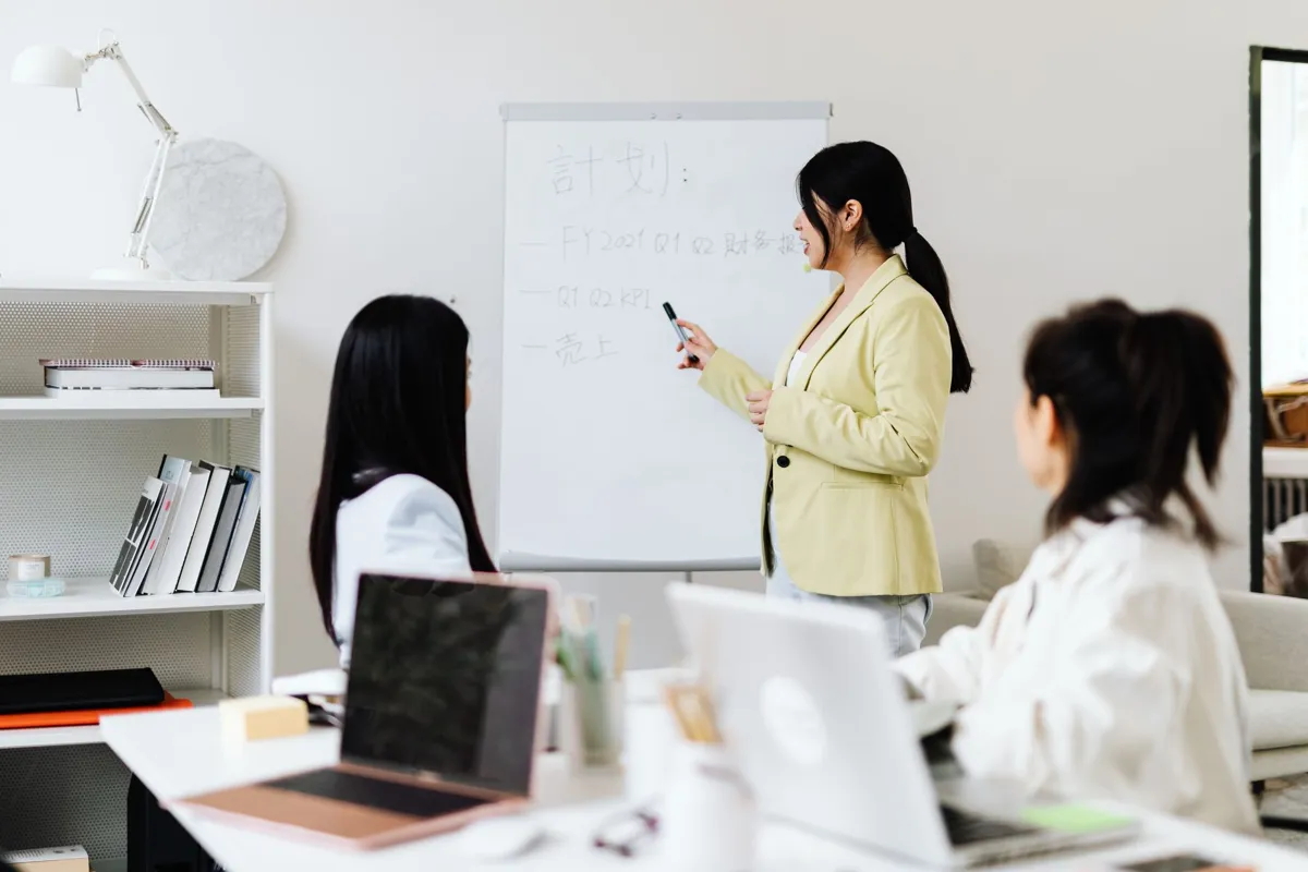 Trainer teaching a small class with laptops