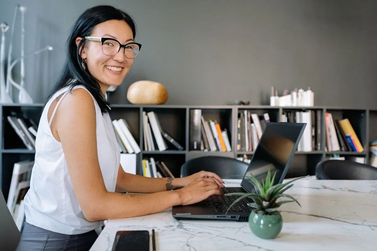 Professional smiling while working on a laptop